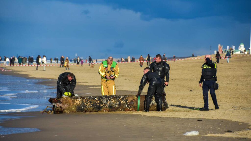 WWII torpedo remnant discovered on a Dutch beach, prompting a beach closure. Defense teams confirmed no explosives, and the artifact was safely removed by experts.