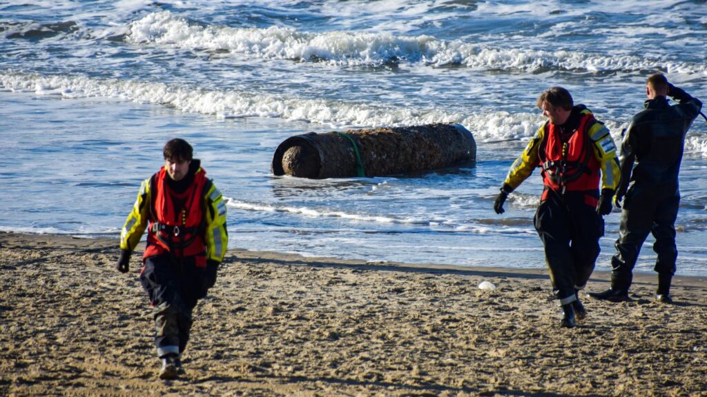 WWII torpedo remnant discovered on a Dutch beach, prompting a beach closure. Defense teams confirmed no explosives, and the artifact was safely removed by experts.