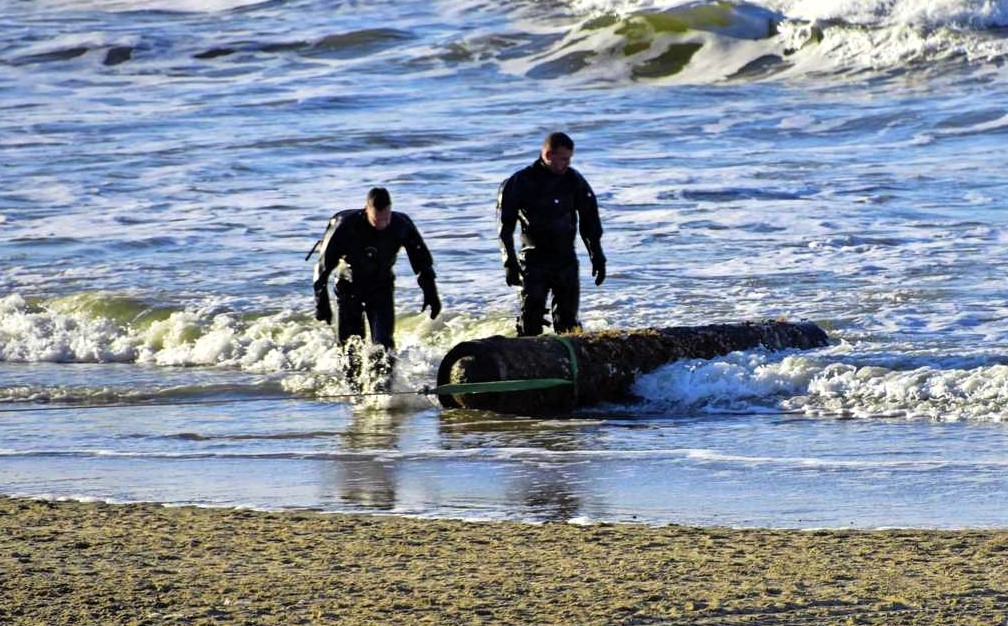 WWII torpedo remnant discovered on a Dutch beach, prompting a beach closure. Defense teams confirmed no explosives, and the artifact was safely removed by experts.