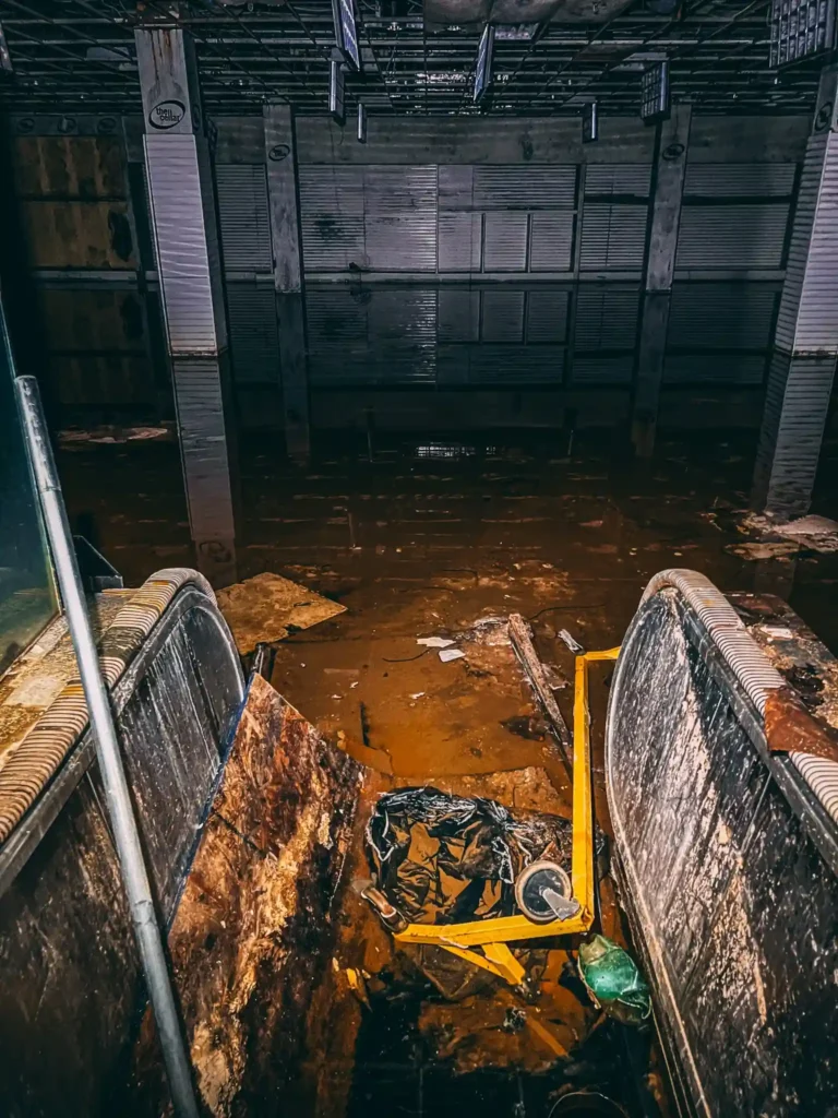 Explore the eerie remains of an abandoned Ohio mall, frozen in time with flooded floors, graffiti, and retro posters, sparking comparisons to The Last of Us.