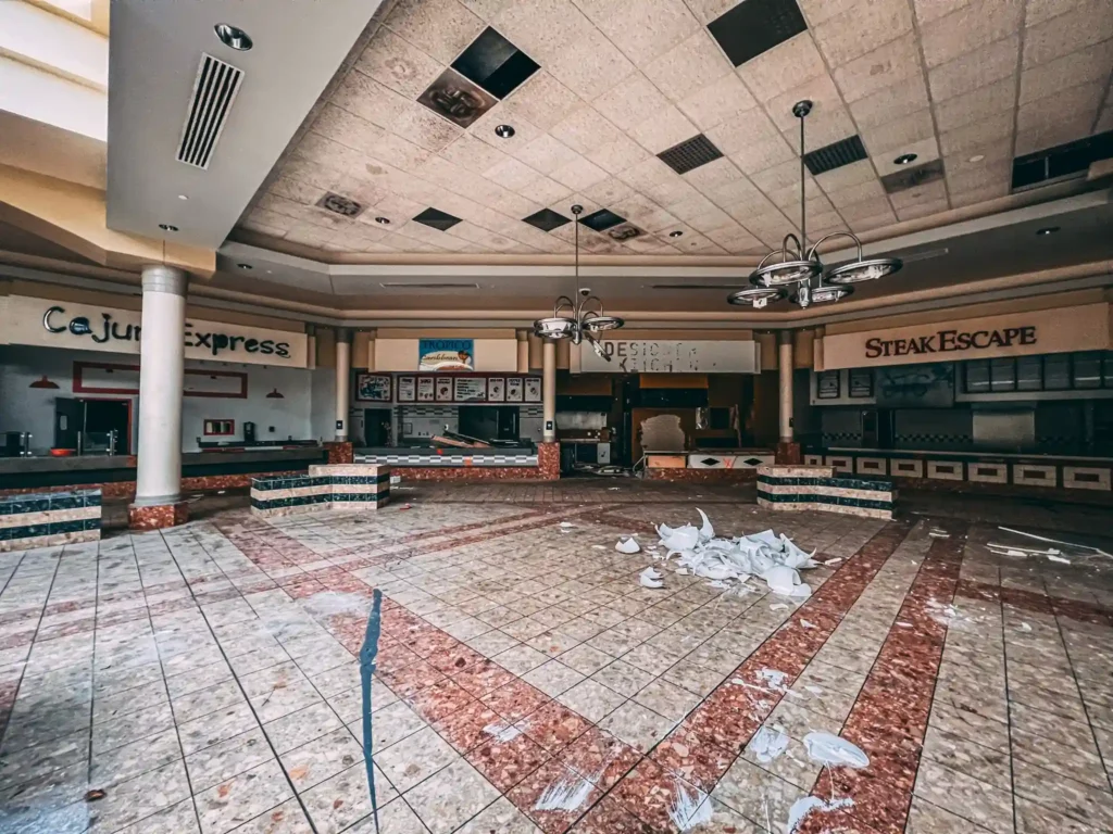 Explore the eerie remains of an abandoned Ohio mall, frozen in time with flooded floors, graffiti, and retro posters, sparking comparisons to The Last of Us.