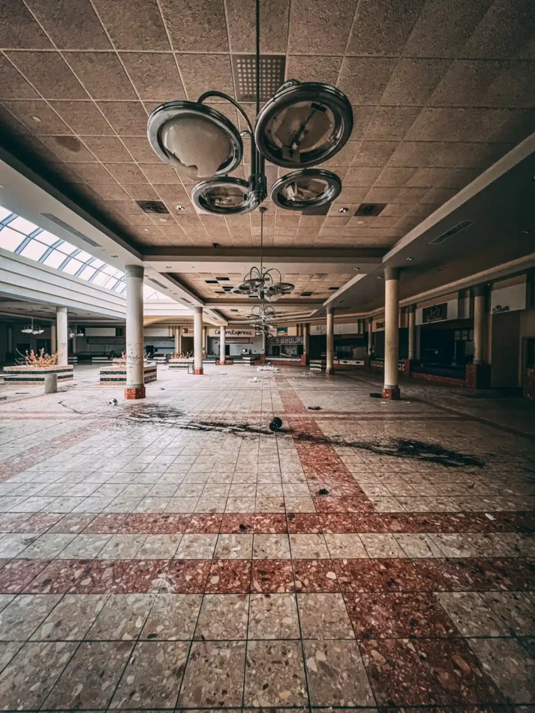 Explore the eerie remains of an abandoned Ohio mall, frozen in time with flooded floors, graffiti, and retro posters, sparking comparisons to The Last of Us.