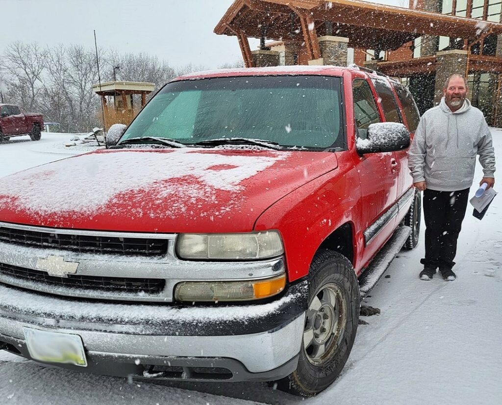 Lottery winner drives his "rusty" 2001 Chevrolet Suburban with 849,000 miles through a snowstorm to claim £122k prize, planning a "major upgrade" to a new pickup truck.