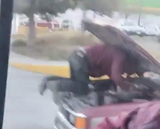 A mechanic was spotted fixing an engine on a moving truck in Mexico, with the driver peering past the raised bonnet. The shocking motorway stunt left locals outraged.