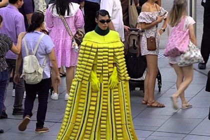 Man in a Scotch-brite sponge dress and woman with a Post-it note bag turn heads in Singapore, part of Lazada's bold campaign redefining fashion as everyday essentials.