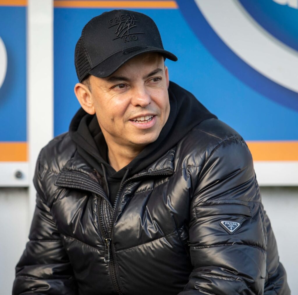 Dorking Wanderers' manager Marc White is retiring his "lucky" trenchcoat after 25 years, 1,000 matches, and 12 promotions. The iconic coat will be gifted to a fan this weekend.