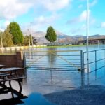 Porthmadog FC's historic Y Traeth ground, one of the UK's oldest football venues, has been submerged under water due to heavy rain. Locals joke about water polo as fixtures are postponed.