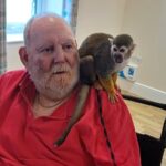 Care home residents delighted by surprise visit from playful squirrel monkeys - a heartwarming day filled with laughter, cuddles, and lifelong dreams coming true!