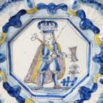 Two rare 17th-century Delftware plates, once carried to Antiques Roadshow in a handbag, have sold for over £20,000 despite one being broken in half.