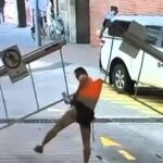 A man’s attempt to crawl under a car park barrier backfired spectacularly when it lifted - hoisting him into the air and ripping off his shirt in a viral CCTV mishap.