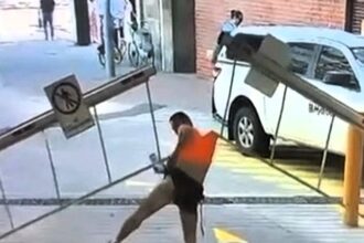 A man’s attempt to crawl under a car park barrier backfired spectacularly when it lifted - hoisting him into the air and ripping off his shirt in a viral CCTV mishap.