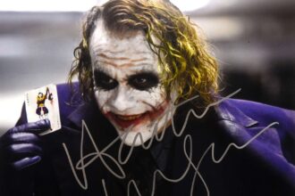 A signed Heath Ledger Joker photo, autographed a month before his death, sold for £5,460 at auction - 13 times its estimate. The rare collectible drew intense bidding.