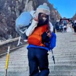 A tour guide in China is earning over £31,920 a year by carrying exhausted female tourists up Mount Tai, with high demand leading him to hire a team to assist.