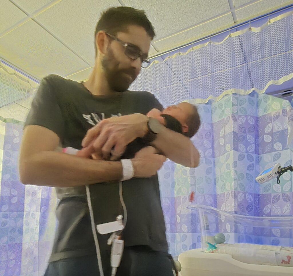 Dad-to-be brings TV and Xbox to hospital for birth, sparking backlash on TikTok - but partner reveals it was all to comfort her, not game, during labour stay.