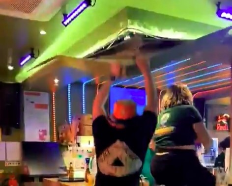 A football fan celebrating to YMCA accidentally ripped down a bar ceiling in the Netherlands after falling off a stool and grabbing the panel, startling staff and patrons.