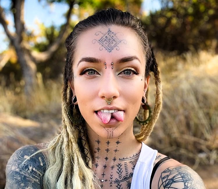 Body mod fan Flower relearned to speak after a painful tongue split, part of her £8.5k transformation including tattoos, piercings, and plans for ear pointing and fangs.