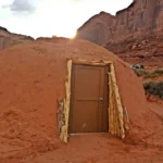 Stay off-grid in a traditional Navajo earthen home in Monument Valley with desert views, native hospitality, and a rustic yet charming experience from just £127 a night.