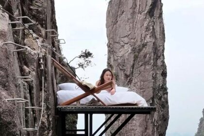 Perched 100m high on a cliff in China, The Cliff Bed offers stunning views, a cozy setup with coffee, and a thrill for selfie lovers seeking a unique escape.