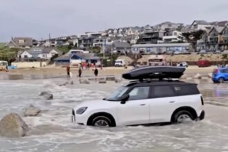 Tourists were warned after a Mini was nearly swept out to sea by a spring tide in Cornwall - locals mocked the beach parking fail as a yearly holiday tradition.