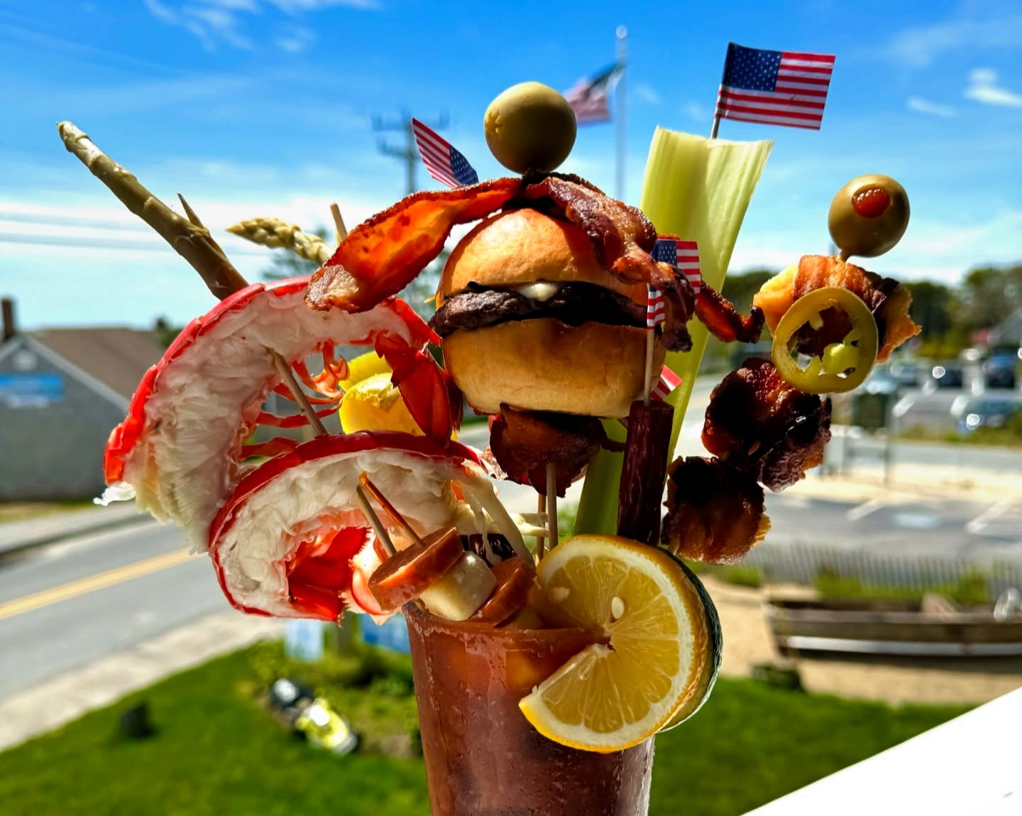 A viral Bloody Mary from Skipper Chowder House in Cape Cod stuns with its towering stack of lobster, shrimp, a burger, and more, earning fame as the East Coast’s wildest cocktail.