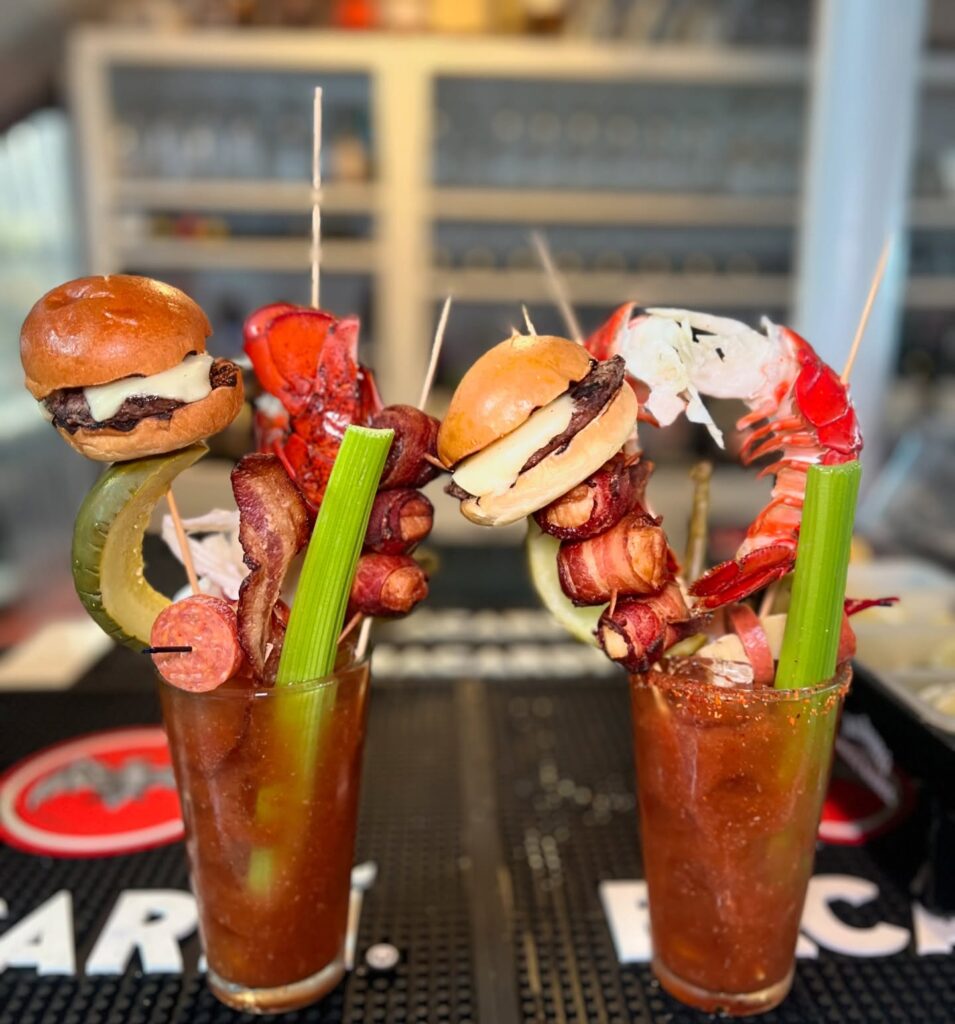 A viral Bloody Mary from Skipper Chowder House in Cape Cod stuns with its towering stack of lobster, shrimp, a burger, and more, earning fame as the East Coast’s wildest cocktail.