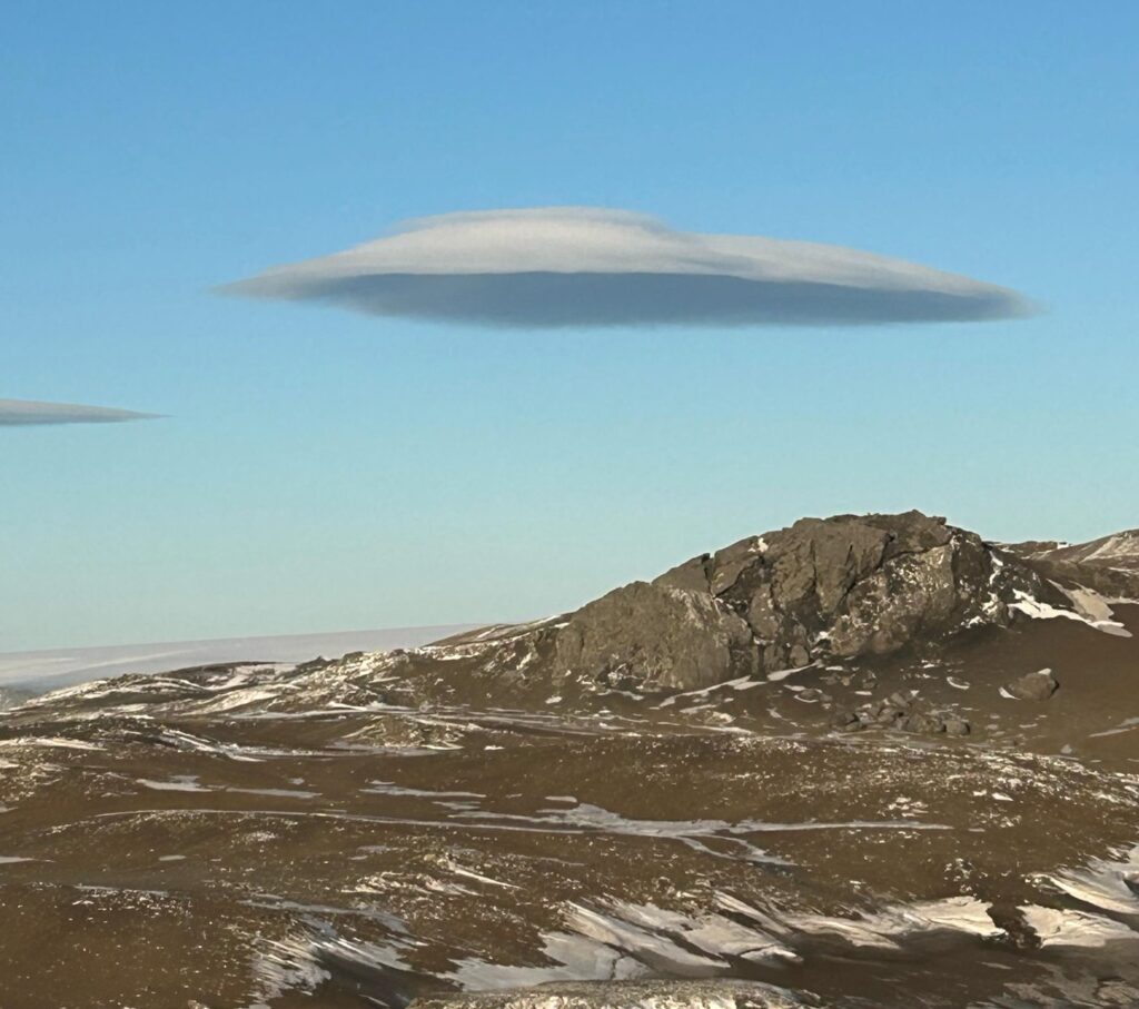 A stunning lenticular “UFO cloud” was spotted over Antarctica, forming near a mountain on King George Island and sparking awe with its saucer-like shape in the sky.