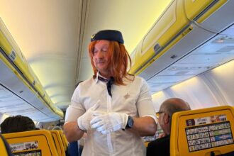 Groom-to-be pranked as cabin crew on flight to stag do - dons uniform, helps with safety demo and rubbish collection as passengers and Ryanair staff enjoy the laughs.