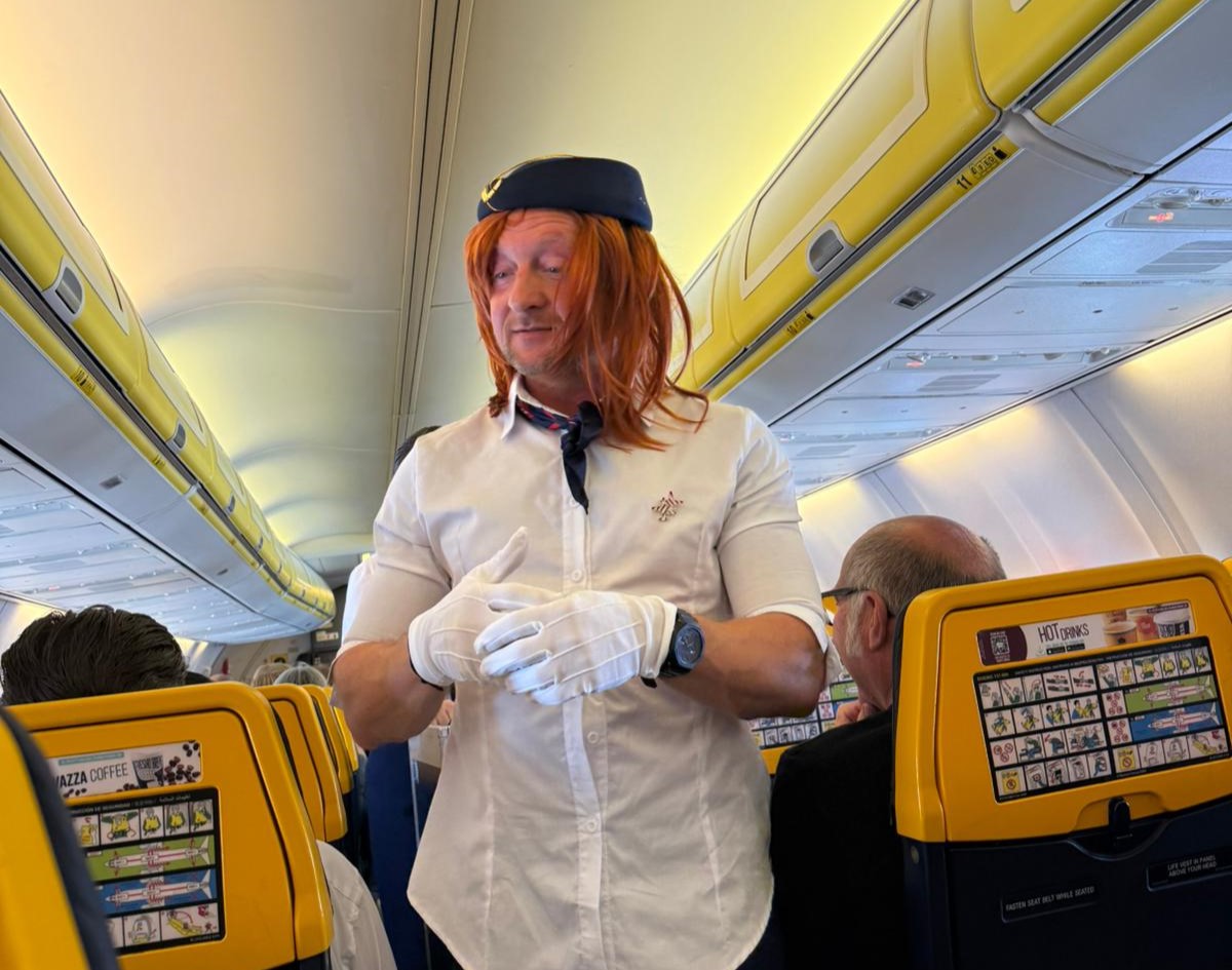Groom-to-be pranked as cabin crew on flight to stag do - dons uniform, helps with safety demo and rubbish collection as passengers and Ryanair staff enjoy the laughs.