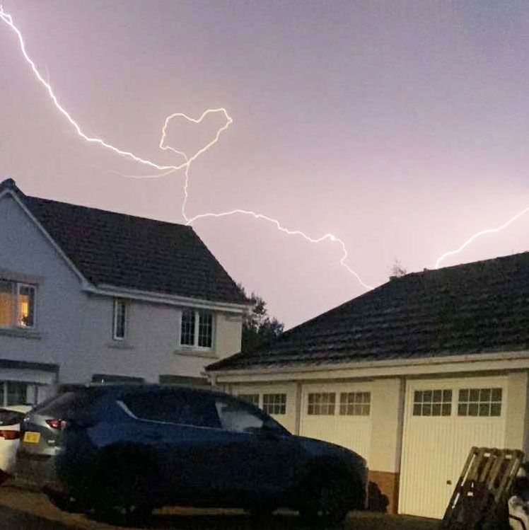 Teen captures heart-shaped lightning bolt during storm over Tweedbank village - rare pink sky flash stuns locals and sparks emotional reactions online.