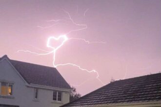 Teen captures heart-shaped lightning bolt during storm over Tweedbank village - rare pink sky flash stuns locals and sparks emotional reactions online.