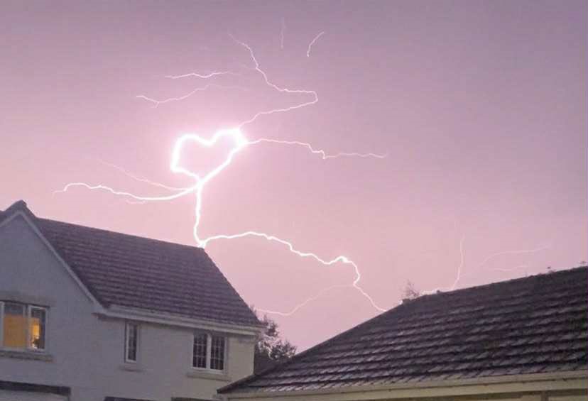Teen captures heart-shaped lightning bolt during storm over Tweedbank village - rare pink sky flash stuns locals and sparks emotional reactions online.