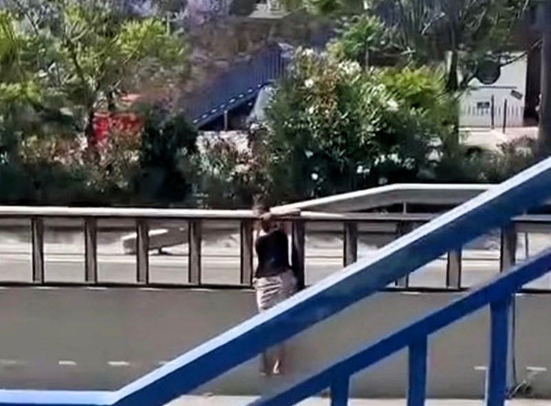 A woman was filmed dangerously crossing Spain's A7 motorway instead of using a nearby footbridge - locals say she does it often and fear a serious accident is imminent.