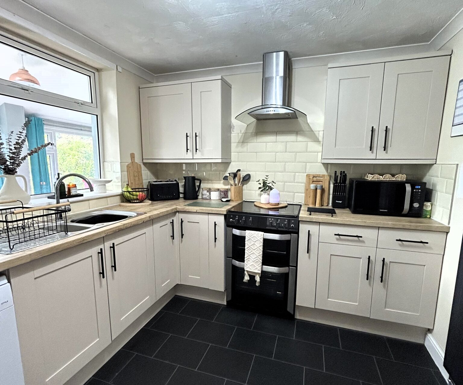 Dental nurse transforms dark kitchen for just £150 using paint, vinyl and DIY hacks, avoiding £3,000 renovation and stunning TikTok with her stylish budget makeover.