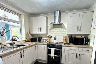 Dental nurse transforms dark kitchen for just £150 using paint, vinyl and DIY hacks, avoiding £3,000 renovation and stunning TikTok with her stylish budget makeover.