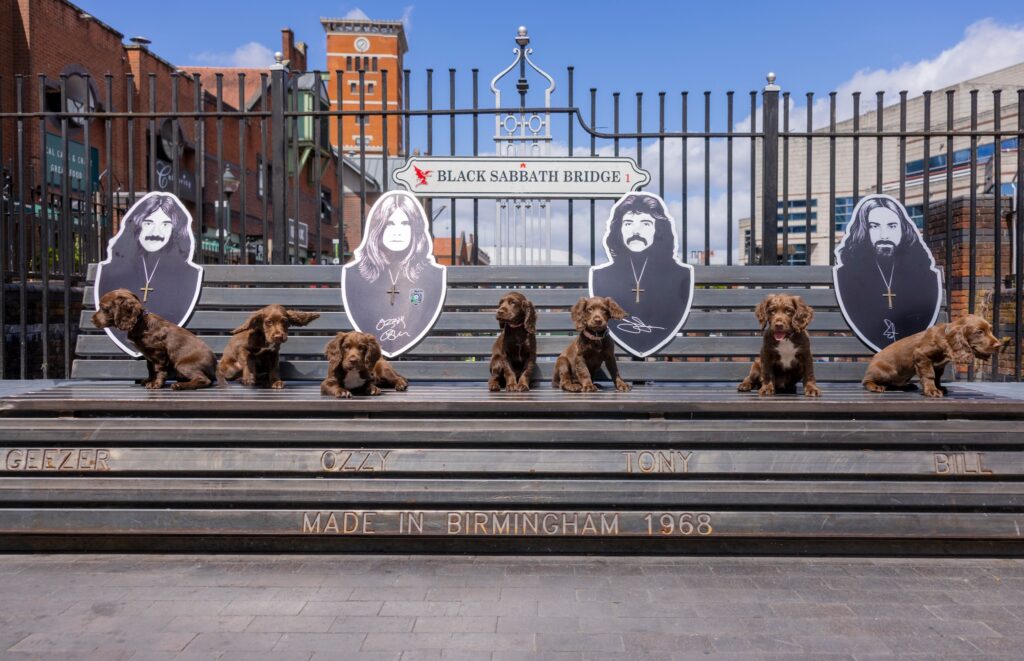 Police puppy Ozzy, named after rock icon Ozzy Osbourne, paid tribute to the late star by posing on Birmingham’s Black Sabbath bench, honoring his legendary legacy.