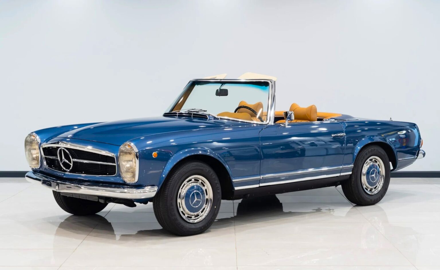 A vintage 1969 Mercedes-Benz 280SL once owned by Vasco Gucci is for sale at £85,000, featuring luxe cognac leather, low mileage, and a Gucci bag for the winning bidder.