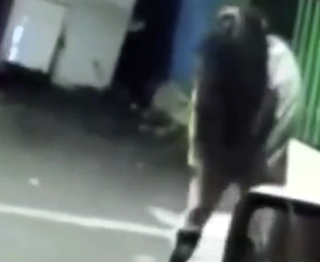 Scared cops film spooky woman in white coat and stockings standing still in Mexico City alley with hair covering face as video sparks eerie reactions online.