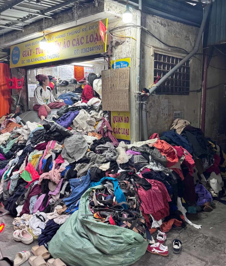 Tourist shocked by chaotic thrift market in Hanoi with mountains of clothes stacked to the ceiling - viral video sparks concerns over hygiene and safety risks.