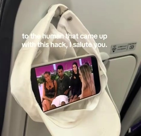 Maddison Gordon wowed passengers with a clever in-flight hack using just a hat and her phone, turning the coat hook into a mini screen holder for hands-free entertainment.