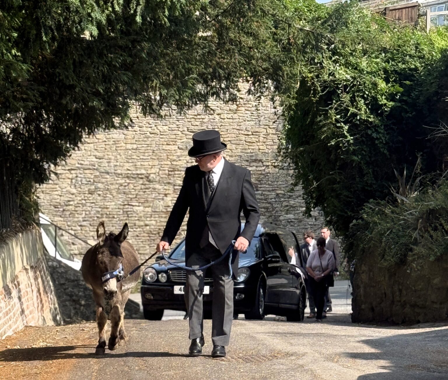 Donkey leads funeral procession of 78-year-old Val Mortimer in Wiltshire as touching tribute to her lifelong love of the gentle animals and support for donkey charities.