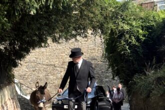 Donkey leads funeral procession of 78-year-old Val Mortimer in Wiltshire as touching tribute to her lifelong love of the gentle animals and support for donkey charities.