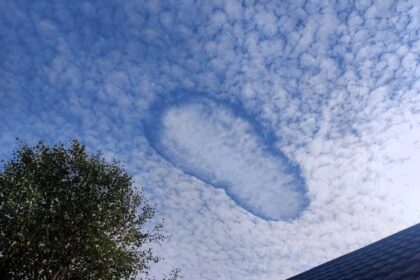 Giant UFO shaped hole appears in sky over Dorset - rare Fallstreak cloud formation stuns locals as trainee paraglider captures the eerie weather phenomenon.