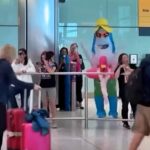 Inflatable shark in sunglasses and rubber ring greets holidaymaker at Heathrow Airport - hilarious reunion stunt leaves passengers in stitches at arrivals hall.