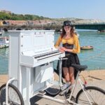 Musician Chloe Marie Aston is touring every UK town on her unique piano bike, bringing music and joy to streets nationwide with her dad by her side for the adventure.