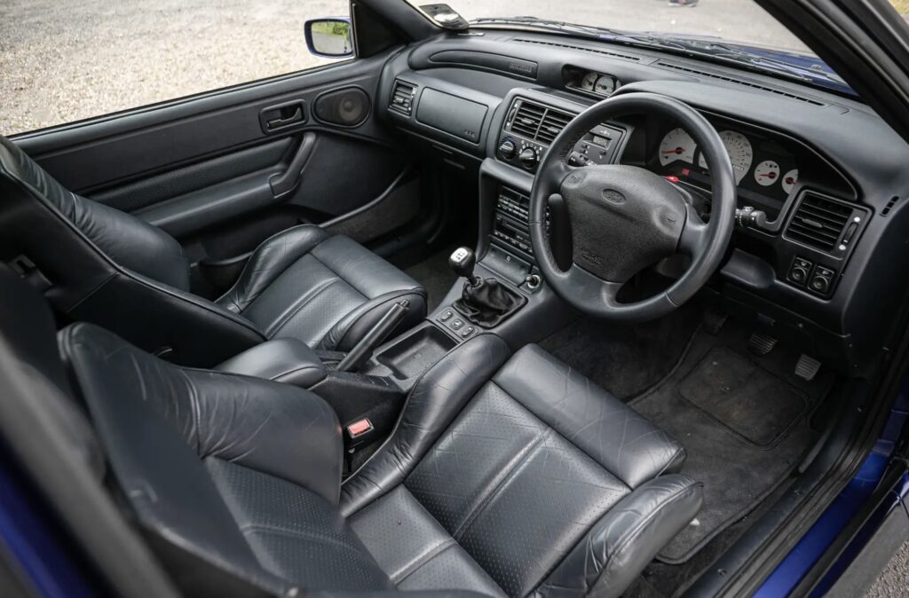 A rare 1996 Ford Escort RS Cosworth Lux with just 22,744 miles sold for £81,563. Iconic whale tail spoiler, 150mph top speed and collector quality make it a gem.