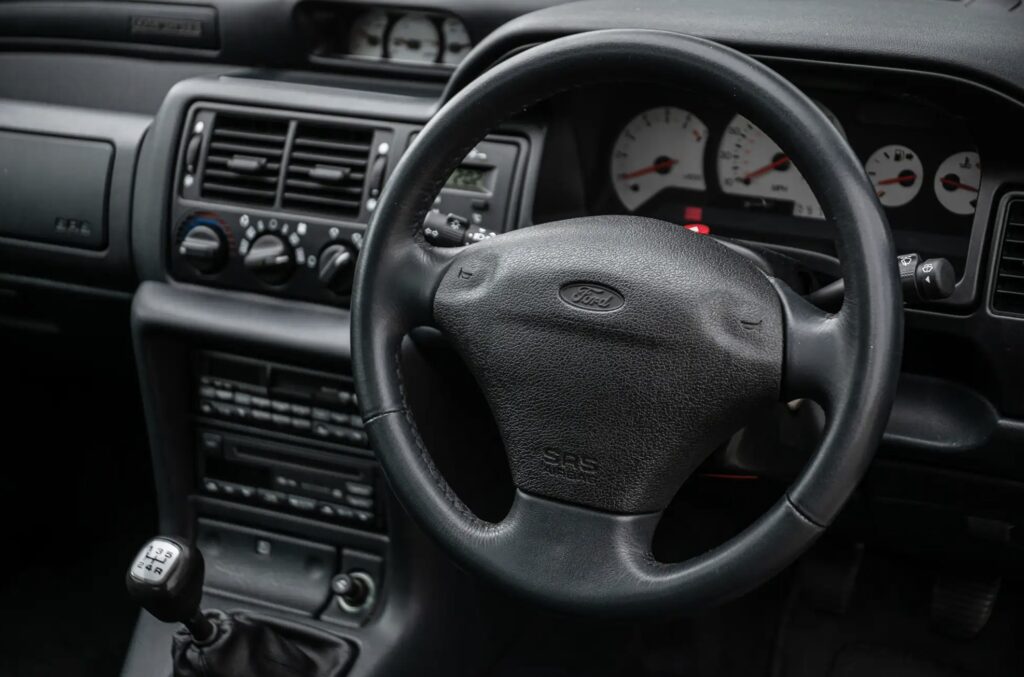 A rare 1996 Ford Escort RS Cosworth Lux with just 22,744 miles sold for £81,563. Iconic whale tail spoiler, 150mph top speed and collector quality make it a gem.