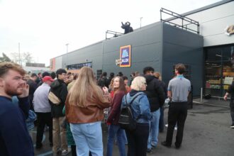 Lewis Capaldi surprises fans by performing his new single on the roof of an Aldi supermarket in Nottingham, leaving shoppers stunned by the unexpected rooftop gig.