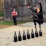 Ballerina balances on pointed toes across seven CHAMPAGNE BOTTLES while dressed as a cat (2)