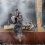 Palestinian photographer Ali Jadallah wins Siena International Photo Awards 2025 with Leaving Home a powerful image of families fleeing rubble in Gaza after an airstrike.