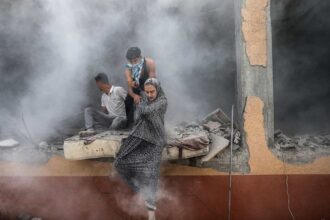 Palestinian photographer Ali Jadallah wins Siena International Photo Awards 2025 with Leaving Home a powerful image of families fleeing rubble in Gaza after an airstrike.